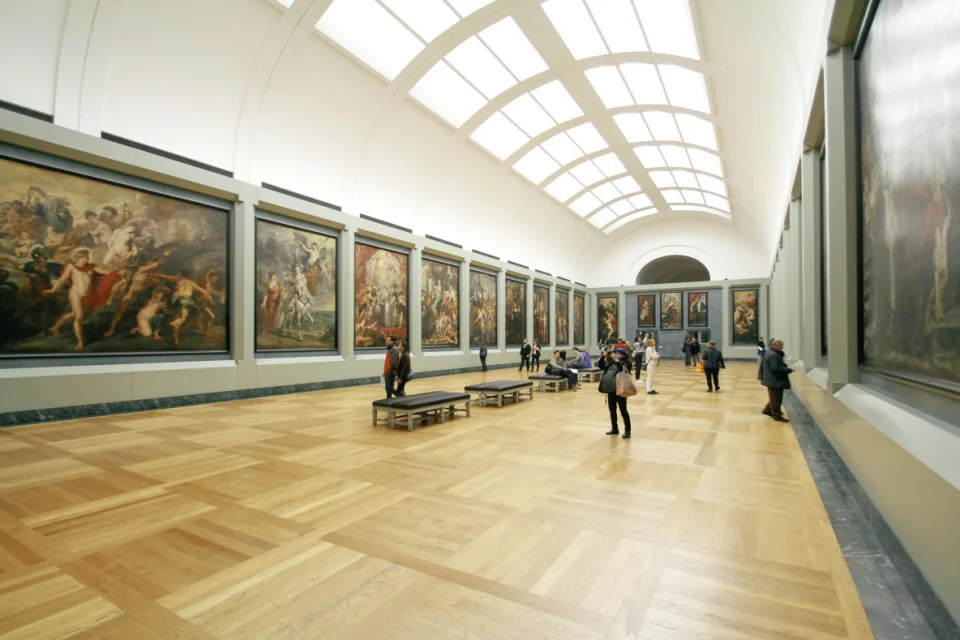 Ein Raum in einem Museum mit großen Gemälden.